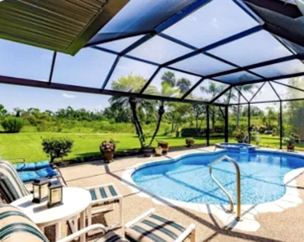 Screened pool enclosure with a river rock deck